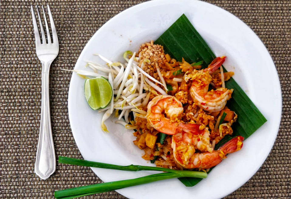 White plate that has pad thai on it.